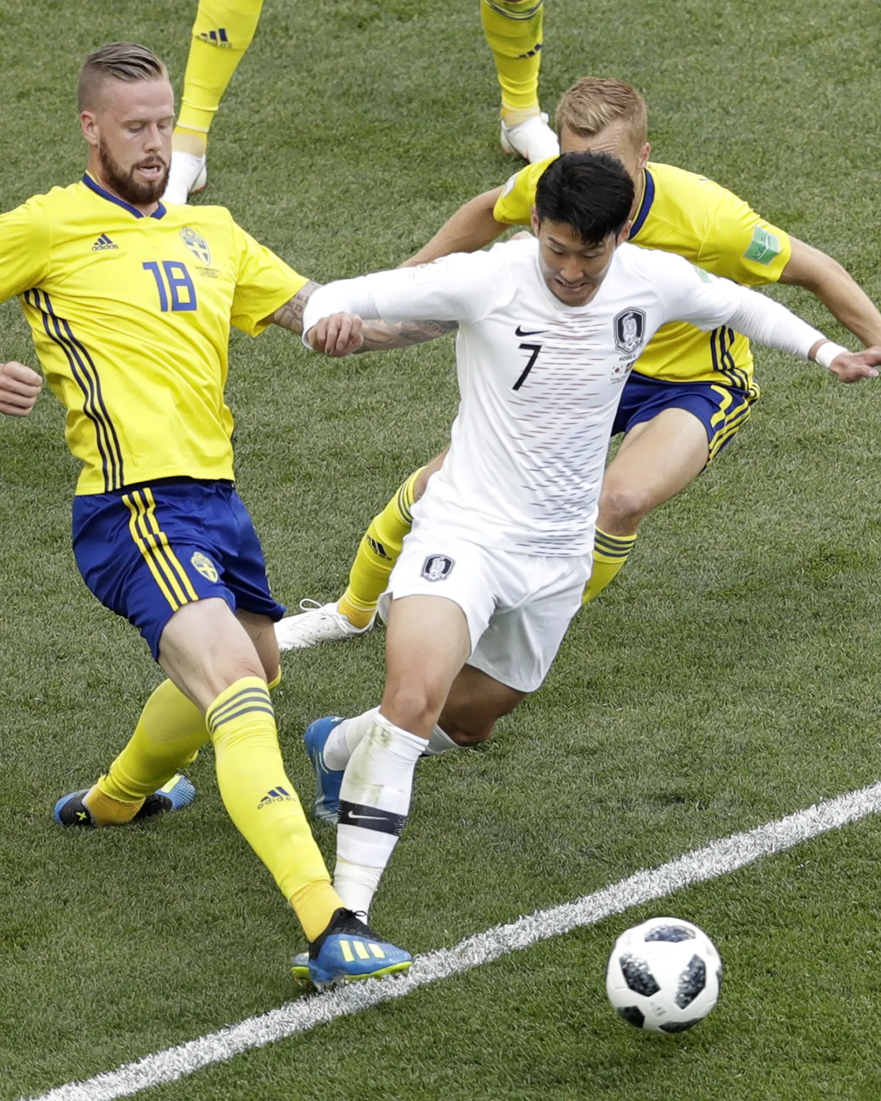 Aksi pemain Korea Selatan, Son Heung-min melewati adangan dua pemain Swedia pada laga grup E Piala Dunia 2018 di Nizhny Novgorod stadium, Nizhny Novgorod, Rusia, (18/6/2018). Swedia menang 1-0. (AP/Michael Sohn)