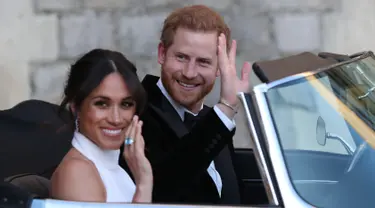 Pangeran Harry dan istrinya Meghan Markle tersenyum saat meninggalkan Kastil Windsor untuk ke acara resepsi dekat Frogmore House (19/5). Mobil yang dikenderai Pangeran Harry yaitu Jaguar Classic E-Type Concept Zero.  (AFP Photo/Pool/Steve Parsons)