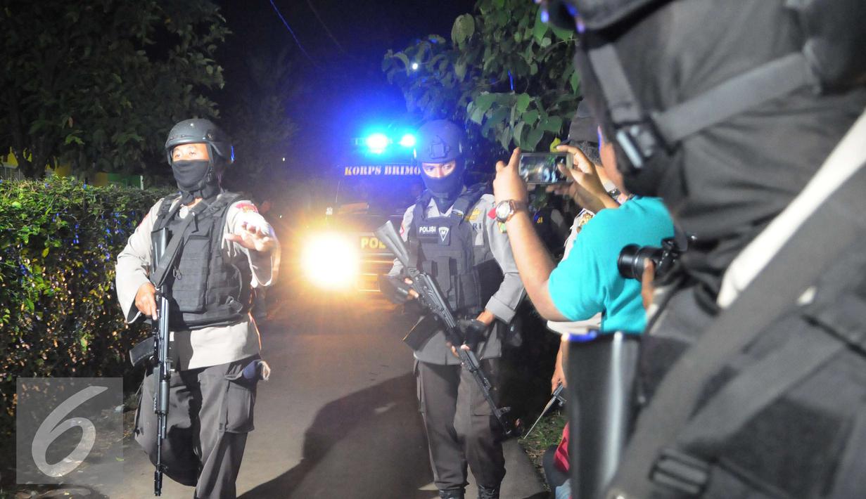 Petugas mengawal ambulan yang berisi mayat terduga teroris di Setu, Tangerang Selatan, Banten, Rabu (21/12). Densus 88 terlibat baku tembak yang akhirnya menewaskan tiga orang terduga teroris. (Liputan6.com/Helmi Afandi)
