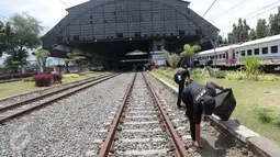Komunitas Pecinta Kereta Api RD One memungut sampah yang berada di sekitaran Stasiun Tanjung Priok, Jakarta Utara, Kamis (6/4). Acara HUT diakhiri dengan doa bersama dan ramah tamah antar anggota pecinta kereta api. (Liputan6.com/Gempur M. Surya)