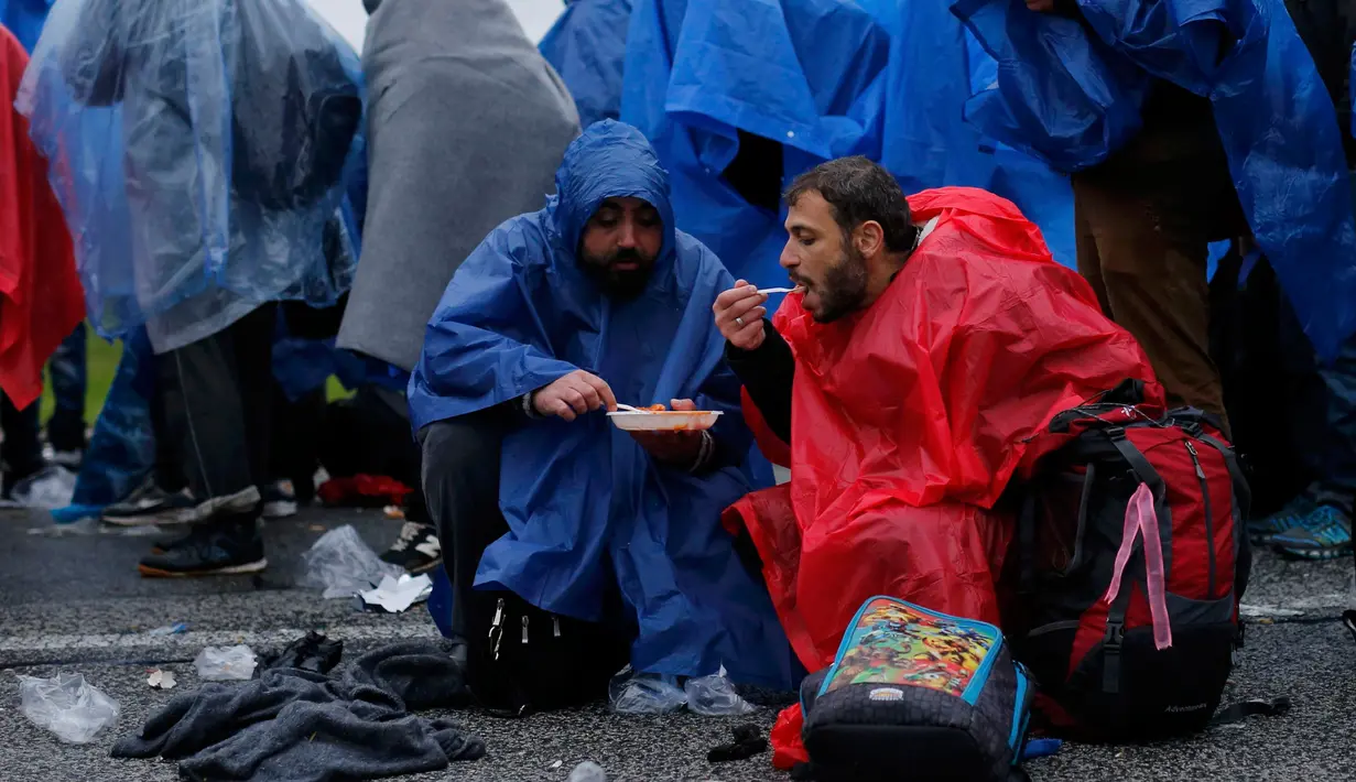Para pengungsi saat menunggu menyeberang perbatasan dari Slovenia menuju Trnovec, Kroasia, Senin (19/10). Ribuan orang terjebak cuaca dingin di desa perbatasan Serbia Berkasovo setelah Kroasia membendung para pendatang. (REUTERS/Antonio Bronic)