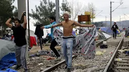 Imigran memberikan perlawanan saat Polisi Makedonia melarang para imigran mendirikan tenda di sekitar rel kereta api di Desa Idomeni, Yunani (28/11/2015). (REUTERS/Yannis Behrakis)