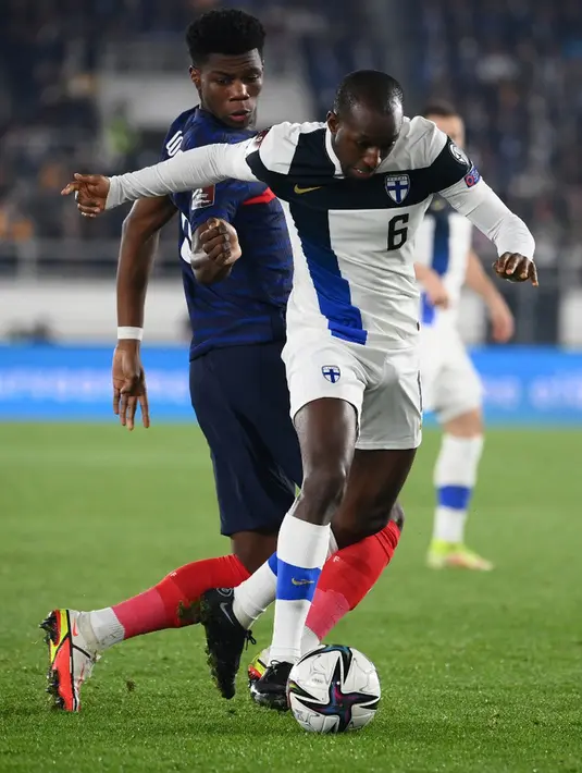 Pemain Prancis Aurelien Tchouameni (kiri) dan pemain Finlandia Glen Kamara bersaing memperebutkan bola pada pertandingan sepak bola kualifikasi Grup D Piala Dunia 2022 di Stadion Olimpiade, Helsinki, Finlandia, 16 November 2021. Prancis menang 2-0. (FRANCK FIFE/AFP)