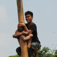 Ekpresi salah satu peserta lomba panjat pinang dalam rangka memeriahkan HUT RI ke-69 di kawasan Tugu Monas, Jakarta, (31/8/2014). (Liputan6.com/Helmi Fithriansyah)