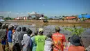 Para penonton menyaksikan seorang peserta menaiki gerobak saat acara Karapan Sapi Brujul di Probolinggo, Jawa Timur pada Minggu 24 Mei 2026. (Juni KRISWANTO/AFP)