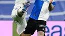 Bek Real Madrid Eder Militao (kiri) berebut bola dengan penyerang Deportivo Alaves Joselu pada pekan ke-25 La Liga Spanyol di Santiago Bernabeu, Minggu (20/2/2022) dinihari WIB. Real Madrid menang meyakinkan dengan skor 3-0. (OSCAR DEL POZO / AFP)