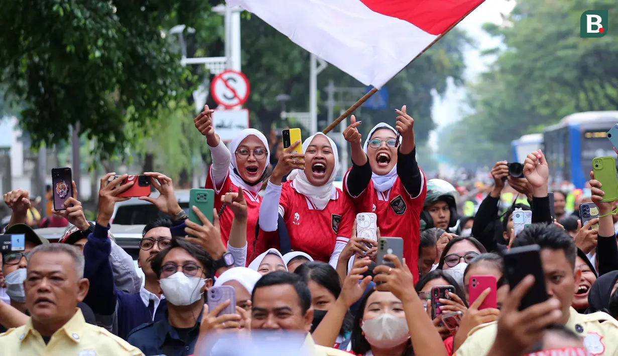 Reaksi masyarakat saat menyambut Timnas Indonesia U-22 dan kontingen Indonesia untuk SEA Games 2023 saat pawai Kira87uara yang berlangsung dari Kemenpora hingga GBK, Jakarta, Jumat (19/05/2023). (Bola.com/Bagasakra Lazuardi)