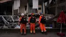 Anggota tim penyelamat Inggris melakukan pencarian di sebuah rumah yang hancur di Antakya, Turki, 9 Februari 2023. Puluhan ribu orang yang kehilangan rumah mereka dalam bencana gempa bumi berkerumun di sekitar api unggun dalam cuaca yang sangat dingin dan berteriak-teriak meminta makanan dan air, tiga hari setelah gempa melanda Turki dan Suriah. (AP Photo/Khalil Hamra)
