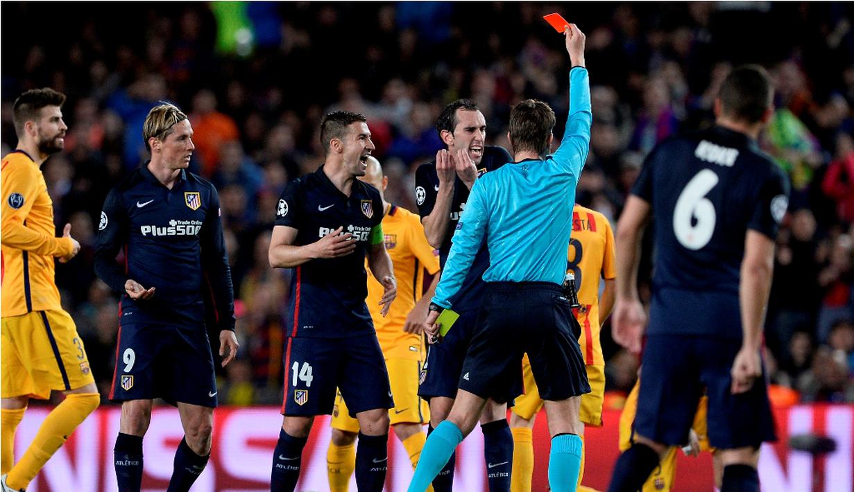 Wasit memberikan kartu merah kepada striker Atletico Madrid, Fernando Torres, setelah melanggar pemain Barcelona, Sergio Busquets, pada leg pertama perempat final Liga Champions di Stadion Camp Nou, Rabu (6/4/2016) dini hari WIB. (AFP/Josep Lago)