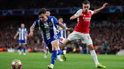 Pemain Arsenal, Leandro Trossard (kanan) berebut bola dengan pemain Porto, Francisco Conceicao pada laga leg kedua 16 besar Liga Champions 2023/2024 di Emirates Stadium, London, Inggris, Rabu (13/03/2024) dini hari WIB. (AFP/Adrian Dennis)