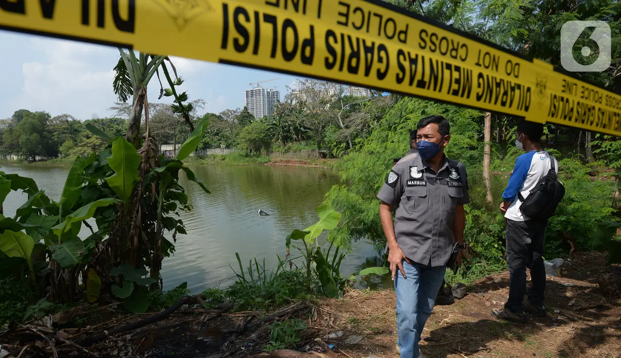 Garis polisi terpasang dekat lokasi jatuhnya sebuah helikopter di Danau Buperta, Kecamatan Cimanggis, Kota Depok, Jumat (28/5/2021). Helikopter itu terjatuh pada sekitar pukul 09.45 WIB, beruntung dua orang di dalam helikopter masih dapat menyelamatkan diri. (merdeka.com/Imam Buhori)