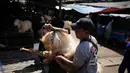 Para pekerja memuat seekor kambing ke bak truk menjelang Hari Raya Idul Adha 1447 Hijriah di Jakarta, Selasa 26 Mei 2026. (AP Photo/Dita Alangkara)