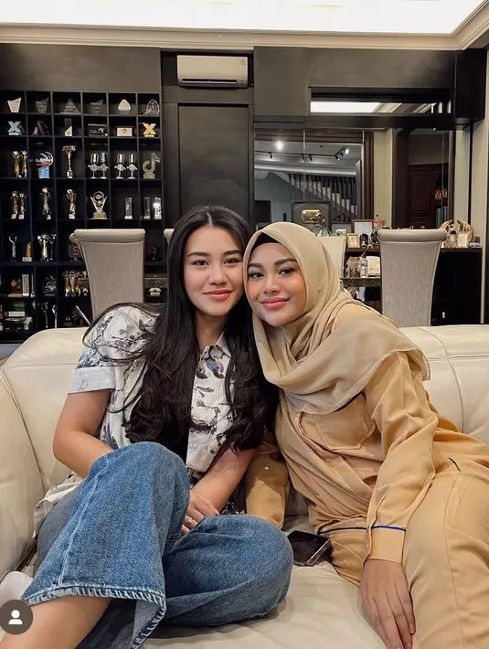 Aaliyah tampil lebih kasual dengan atasan kemeja bermotif dipadukan celana denimnya. Aurel tampil piyama coklat serasi dengan kerudung segi empatnya. [@aaliyah.massaid]