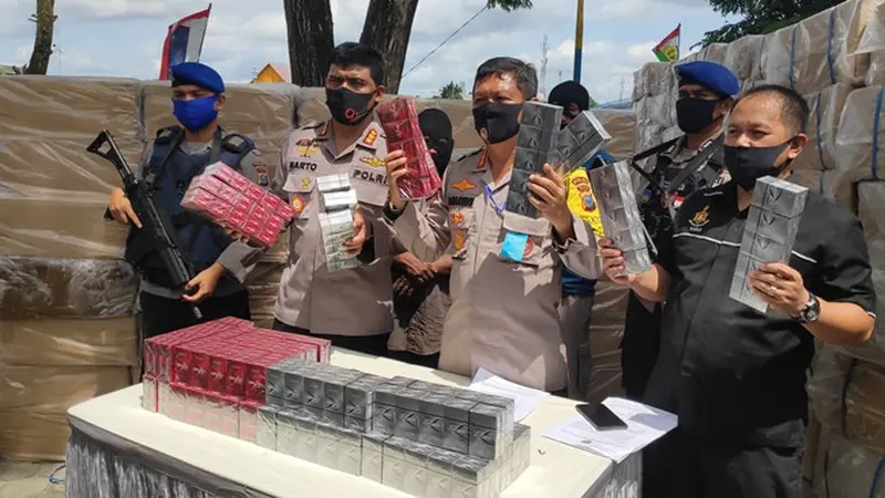 Direktur Polisi Air Polda Riau Komisaris Besar Badarudin bersama tersangka dan barang bukti rokok tanpa cukai.