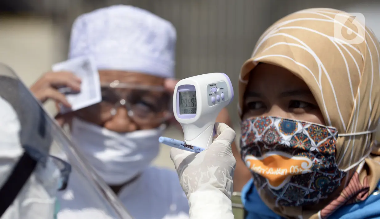Warga menjalani pemeriksaan suhu saat mengikuti swab test di Balai RW 20, Villa Dago, Pamulang, Tangerang Selatan, Banten, Jumat (17/7/2020). Swab test gratis yang dilakukan seiring meningkatnya kasus COVID-19 tersebut diikuti 200 warga dari beberapa RW di Benda Baru. (merdeka.com/Dwi Narwoko)