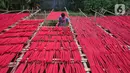Seorang pekerja menjemur hio dupa di sentra industri kecil pembuatan hio di Tangerang, Banten, Senin (9/1/2023). Jelang perayaan Imlek, pesanan hio dupa mengalami peningkatan untuk kebutuhan sembahyang. (Liputan6.com/Angga Yuniar)