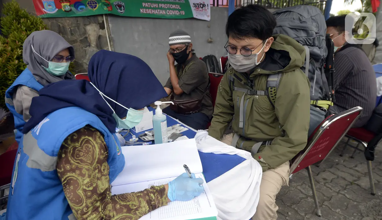 Petugas medis mendata warga saat rapid test di Pos PAM Pamulang Square, Tangerang Selatan, Banten, Jumat (25/12/2020). Rapid test gratis yang digelar Polres Tangerang Selatan tersebut bertujuan untuk mencegah penularan COVID-19 saat Natal dan Tahun Baru. (merdeka.com/Dwi Narwoko)