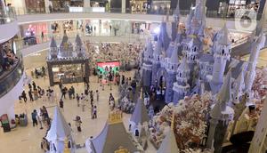 Pengunjung berfoto dengan latar belakang ornamen Natal yang terpajang di Mal Senayan City, Jakarta, Kamis (14/12/2023). (Liputan6.com/Herman Zakharia)