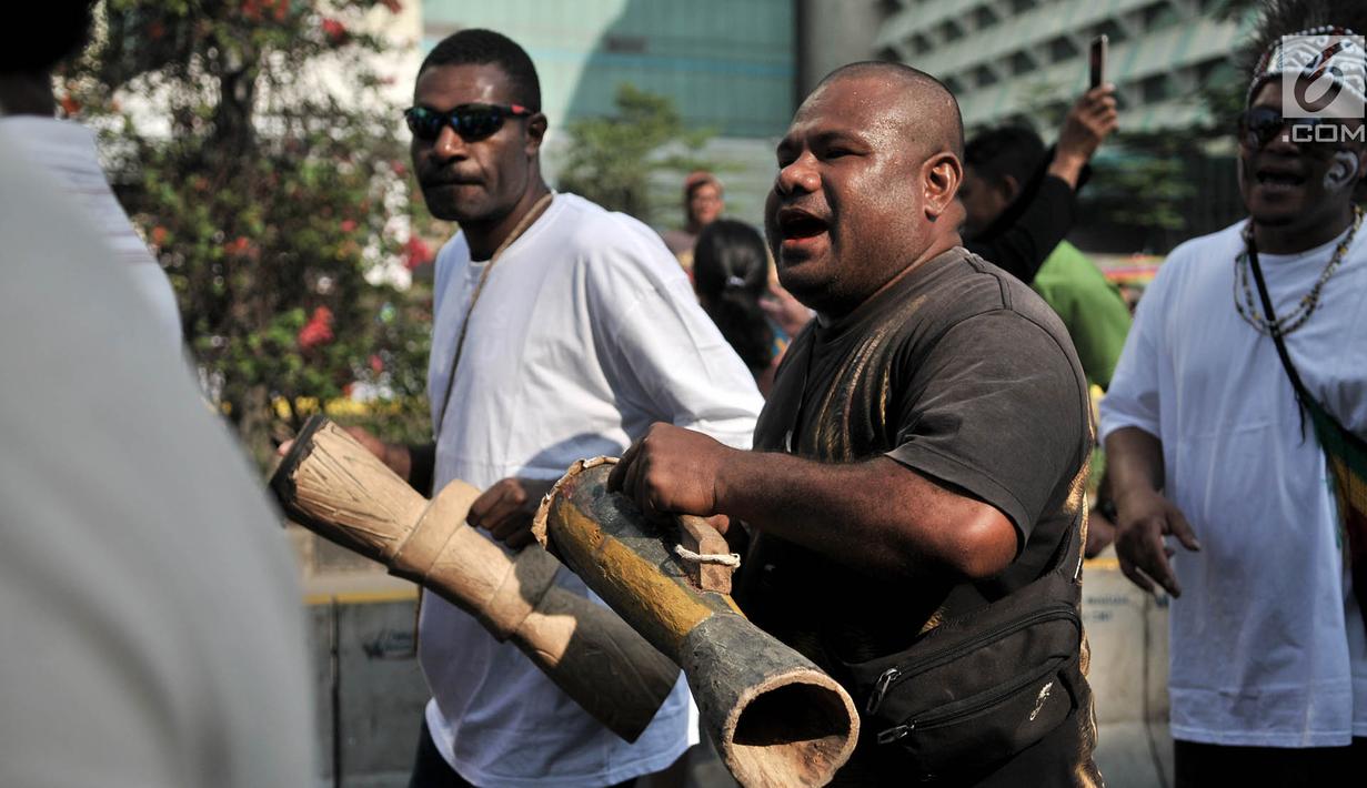 Masyarakat Papua yang merupakan mantan karyawan PT Freeport Indonesia saat melakukan penggalangan dana di tengah berlangsungnya Hari Bebas Kendaraan Bermotor atau Car Free Day di kawasan Bundaran HI, Jakarta, Minggu (5/8). (Merdeka.com/Iqbal S. Nugroho)