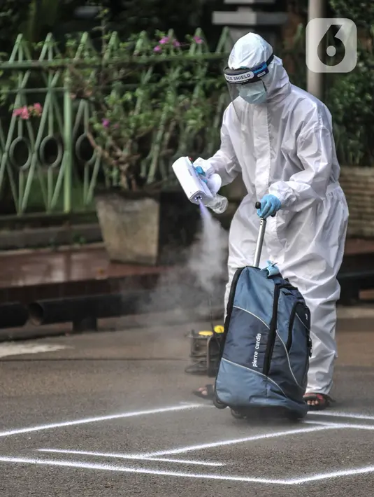 Tenaga kesehatan menyemprotkan disinfektan pada barang bawaan pasien OTG Covid-19 di Graha Wisata TMII, Jakarta, Selasa (22/6/2021). Pihak pengelola Graha Wisata TMII mengungkapkan saat ini sebanyak 72 pasien menjalani isolasi di 33 kamar yang ada. (merdeka.com/Iqbal S Nugroho)