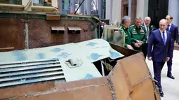 Presiden Vladimir Putin melihat kendaraan tempur saat mengunjungi pameran di markas militer Rusia di Moskow (30/1). Kunjungan Putin sebagai bagian dari sebuah konferensi mengenai kampanye Rusia di Suriah. (Mikhail Klimentyev, Sputnik, Kremlin Pool/AP)