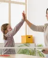seorang ibu dan anak sedang melakukan high-five sambil tersenyum lebar/copyright&nbsp;freepik.com/freepik
