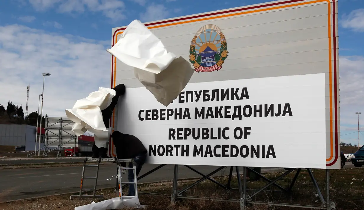 Pekerja mengganti papan nama negara menjadi Republik Makedonia Utara di perbatasan antara negara itu dengan Yunani, dekat Gevgelija, Rabu (13/2). Kini sah sudah Republik Makedonia menyandang nama baru yaitu Republik Makedonia Utara. (AP/Boris Grdanoski)