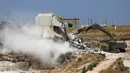 Alat berat Israel menghancurkan salah satu bangunan Palestina di desa Palestina Sur Baher di Yerusalem Timur (22/7/2019). Palestina menuduh Israel menggunakan keamanan sebagai dalih untuk mengusir mereka dari Tepi Barat. (AFP Photo/Ahmad Gharabli)