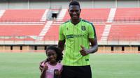 Striker Persebaya Surabaya, Amido Balde, ditemani sang putri, Aixa Balde, saat berlatih di Stadion Gelora Bung Tomo, Surabaya, Jumat (10/5/2019). (Bola.com/Aditya Wany)