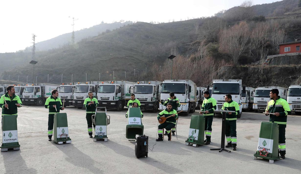 Anggota "Grup Tin" yang bekerja sebagai petugas kebersihan kota memperlihatkan keahlianya bermain musik dengan menggunakan tempat sampah dan barang bekas di distrik Cankaya, Ankara, Turki (9/1). (AFP Photo/Adem Altan)