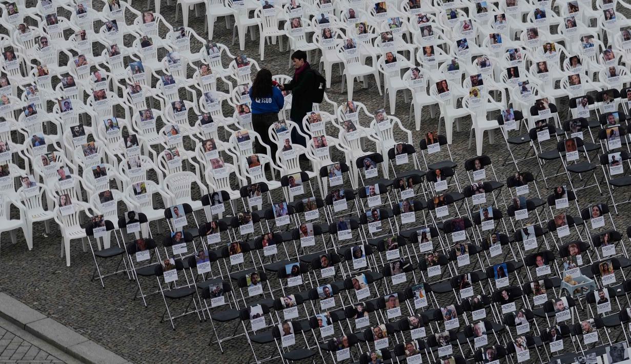 Lebih dari 1.000 kursi dengan foto-foto korban tewas dalam serangan militan Hamas terhadap Israel dipajang di Pariser Platz depan Gerbang Brandenburg, Berlin, Jerman, Selasa 7 Oktober 2025. (AP Photo/Markus Schreiber)