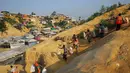 Pengungsi Rohingya membawa batu bata ke lokasi konstruksi di kamp Balukhali di Cox's Bazar, Bangladesh (8/4). (Reuters/Mohammad Ponir Hossain)