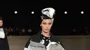 Model cantik, Bella Hadid berjalan di catwalk dalam balutan koleksi Marc Jacobs Spring/Summer 2018 selama New York Fashion Week, Rabu (13/9). Bella tampil sporty memakai jaket warna hitam putih dengan turban warna senada. (SLAVEN VLASIC/GETTY IMAGES/AFP)