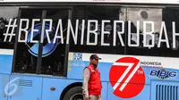 Petugas menjaga perlintasan saat bus TransJakarta koridor 1 dengan stiker tag #Berani Berubah melintas saat Car Free Day (CFD) di Bundaran HI, Jakarta, (14/08). Menjelang HUT Kemerdekaan RI ke 71, sejumlah bus ditempel stiker. (Liputan6.com/Fery Pradolo) 