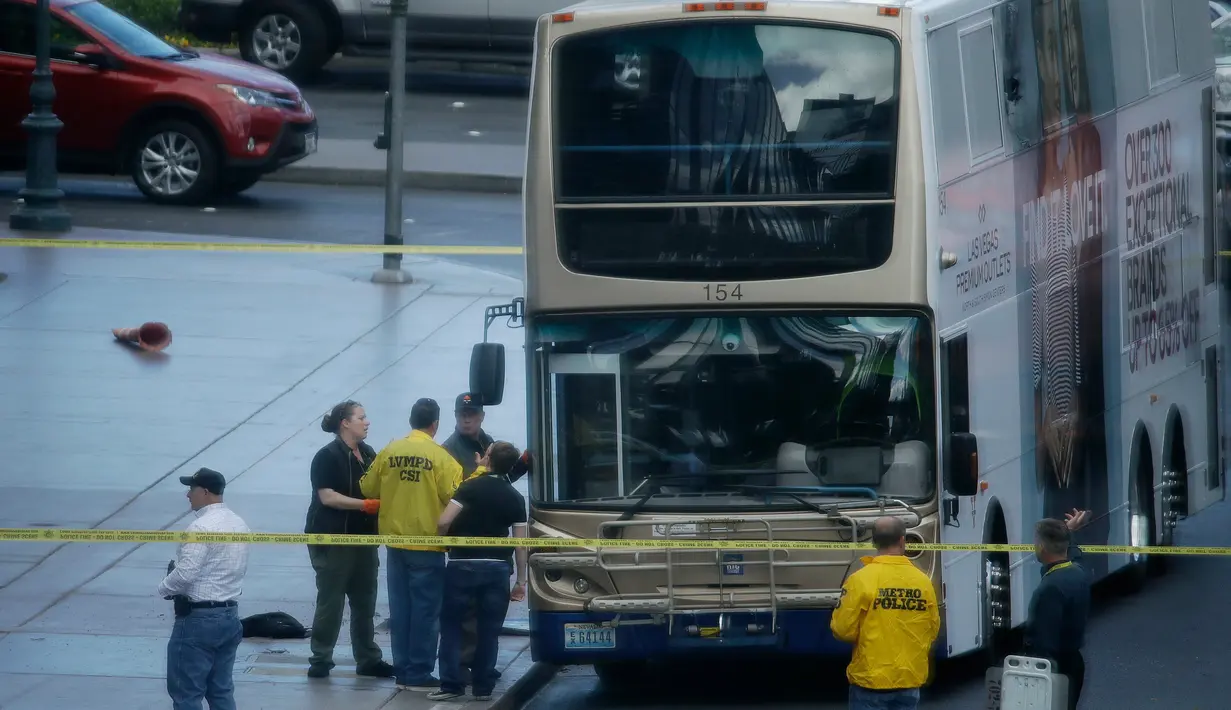 Garis polisi terpasang dekat sebuah bus tingkat di Las Vegas Boulevard, Las Vegas, Sabtu (25/3). Seorang pria yang mengenakan topeng babi tiba-tiba melepaskan tembakan di atas bus tingkat itu dan menewaskan satu orang. (L.E. Baskow/Las Vegas Sun via AP)