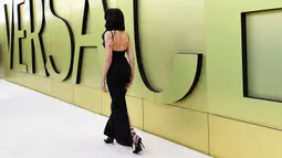 Dua Lipa tiba untuk peragaan busana Versace Fall/Winter 2023 di Pacific Design Center, West Hollywood, California, Amerika Serikat, 9 Maret 2023. Wanita berusia 27 tahun ini melengkapi penampilannya dengan gaun hitam klasik yang diikat ke pinggang. (Jon Kopaloff/Getty Images/AFP)