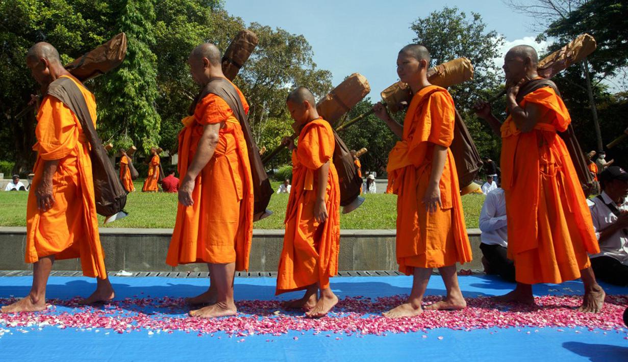 Calon biksu Buddha yang disebut samanera berjalan tanpa alas kaki sekitar empat kilometer dari Candi Mendut ke Candi Borobudur dalam ritual tahunan Pabbaja Samanera, pelatihan moral dan spiritual selama 12 hari bagi calon biksu, di Magelang, Jawa Tengah, 27 Desember 2023. (DEVI RAHMAN/AFP)