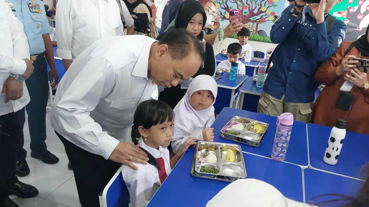Menteri Koperasi Budi Arie Setiadi meninjau Program Makan Bergizi Gratis (MBG) di SD Angkasa 05, Kompleks Halim Perdanakusuma, Jakarta, Senin (6/1/2025). (Liputan6.com/Arief)