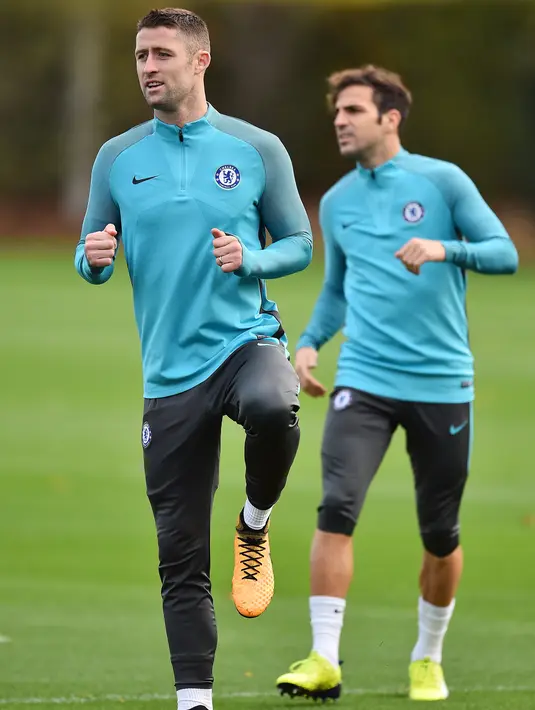 Bek Chelsea, Gary Cahill dan gelandang Cesc Fabregas melakukan pemanasan saat latihan di London, Inggris (17/10). Chelsea akan bertanding melawan wakil Italia, AS Roma pada grup C Liga Champions. (AFP Photo/Glyn Kirk)