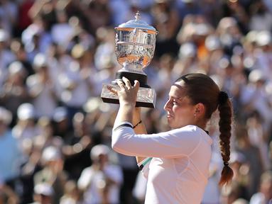 Petenis Latvia,  Jelena Ostapenko mengangkat trofi juara Prancis Terbuka 2017 usai mengalahkan petenis Rumania, Simona Halep di Roland Garros, Paris, (10/6/2017). Ostapenko menang 4-6, 6-4, 6-3. (AP/David Vincent)