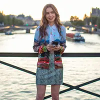 Ini adalah penampilan Lily Collins di Emily in Paris season 1. Ia mengenakan Alice + Olive Eiffel Tower blouse, Ronny Kobo skirt, dan cropped top berwarna putih. Foto: Netflix.