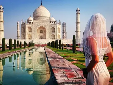 Pavlina Melicharova berfoto menggunakan busana pengantin lamanya di depan masjid ikonik asal India, Taj Mahal. Wanita asal Republik Ceko ini melakukan perjalanan seorang diri berkeliling dunia pasca kegagalan pernikahannya. (facebook.com/TravellingBride)