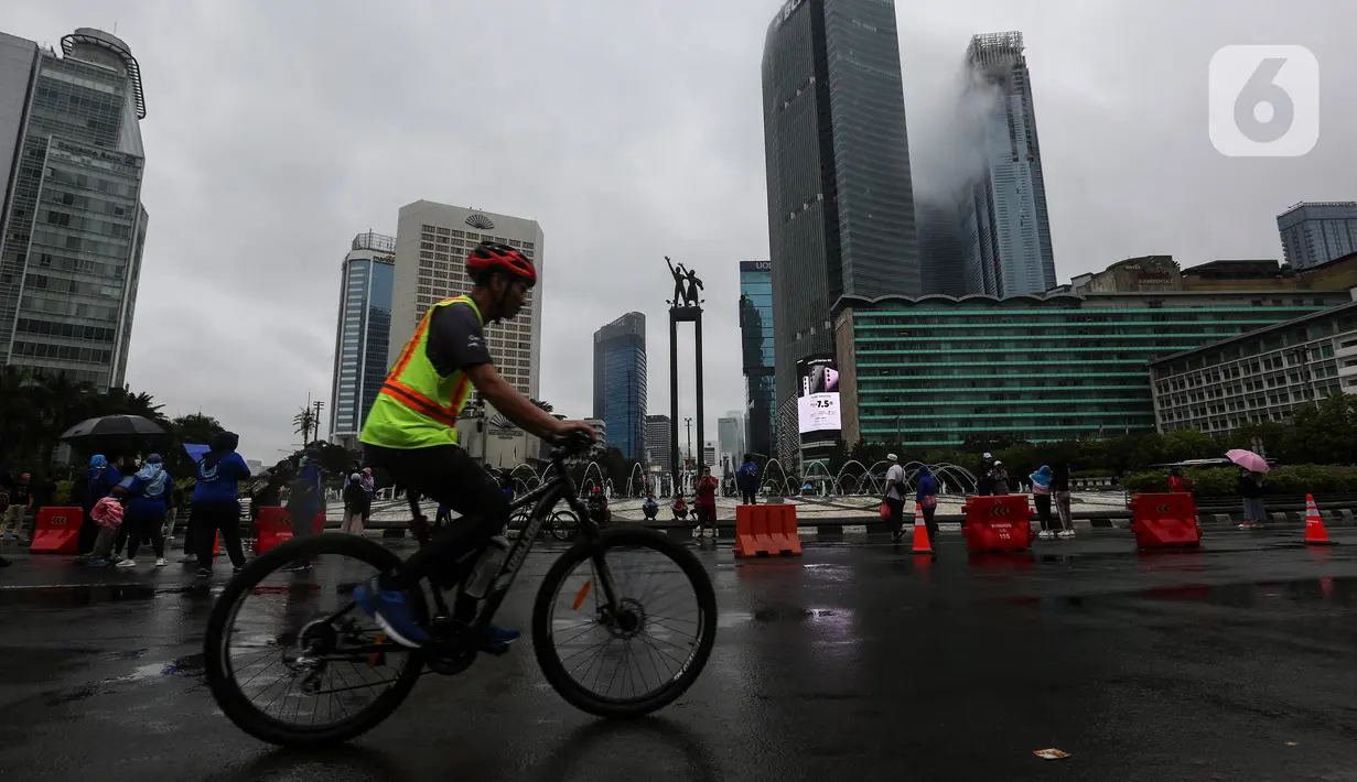 Warga berolahraga di tengah rintik hujan pada Car Free Day atau hari bebas kendaraan di kawasan Bundaran Hotel Indonesia (HI), Jakarta, Minggu (12/2/2023). Hujan telah melanda wilayah Jakarta sejak Sabtu. Terlihat, hingga Minggu pagi, hujan masih terus melanda area ibu kota.(Liputan6.com/Johan Tallo)