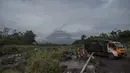 Gunung Semeru menjulang di atas desa Lumajang, Jawa Timur, setelah meletus sehari sebelumnya, Minggu (17/1/2021). Gunung Semeru kembali erupsi dan mengeluarkan awan panas guguran sejauh 4,5 kilometer pada Sabtu (16/1). (Juni Kriswanto / AFP)