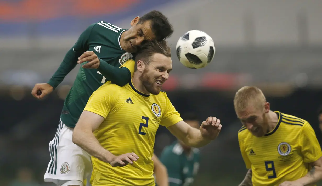 Duel pemain Meksiko, Rafael Marquez (kiri) dengan pemain Skotlandia, Stephen O'Donnell (tengah) pada laga uji coba di Azteca Stadium, Meksiko City, (2/6/2018). Meksiko menang 1-0. (AP/Rebecca Blackwell)