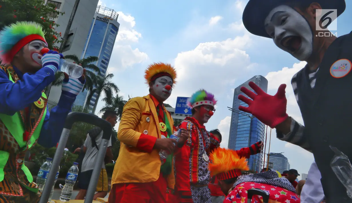 Komunitas Aku Badut Indonesia menggelar aksi penggalangan dana saat Car Free Day (CFD) di kawasan Thamrin, Jakarta, Minggu (6/1). Mereka melakukan atraksi akrobatik untuk menggalang dana bagi korban bencana tsunami Selat Sunda. (Liputan6.com/Johan Tallo)