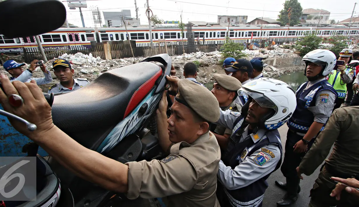 Petugas Dishub mengangkut kendaraan roda dua dalam operasi penertiban parkir liar di Jakarta, Jumat (23/10/2015). Meskipun informasi penertiban diduga telah bocor, ratusan kendaraan yang parkir liar tetap ditertibkan. (Liputan6.com/Immanuel Antonius)