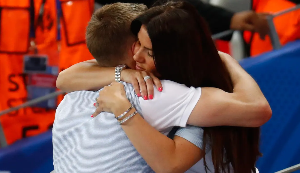 Penyerang Inggris, Jamie Vardy dipeluk sang istri, Ribka Vardy usai laga babak 16 besar Piala Eropa 2016 antara Inggris vs Islandia, di Stade de Nice, Selasa (28/6) dinihari. Inggris menyerah 1-2 dari Islandia. (REUTERS/Kai Pfaffenbach Livepic)