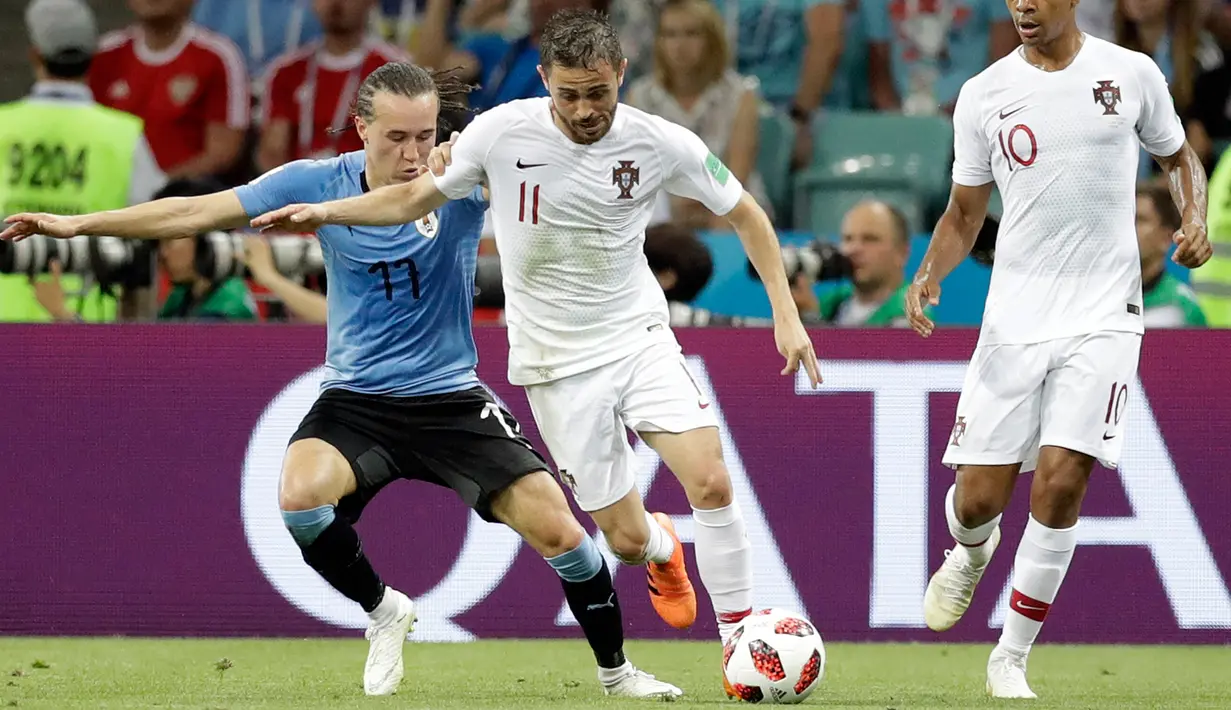 Gelandang Portugal, Bernardo Silva menggiring bola dari kawalan pemain Uruguay Diego Laxalt saat bertanding pada babak 16 besar Piala Dunia 2018 di Stadion Fisht, Sochi, Rusia (30/6). Uruguay menang tipis atas Portugal 2-1. (AP Photo/Andrew Medichini)
