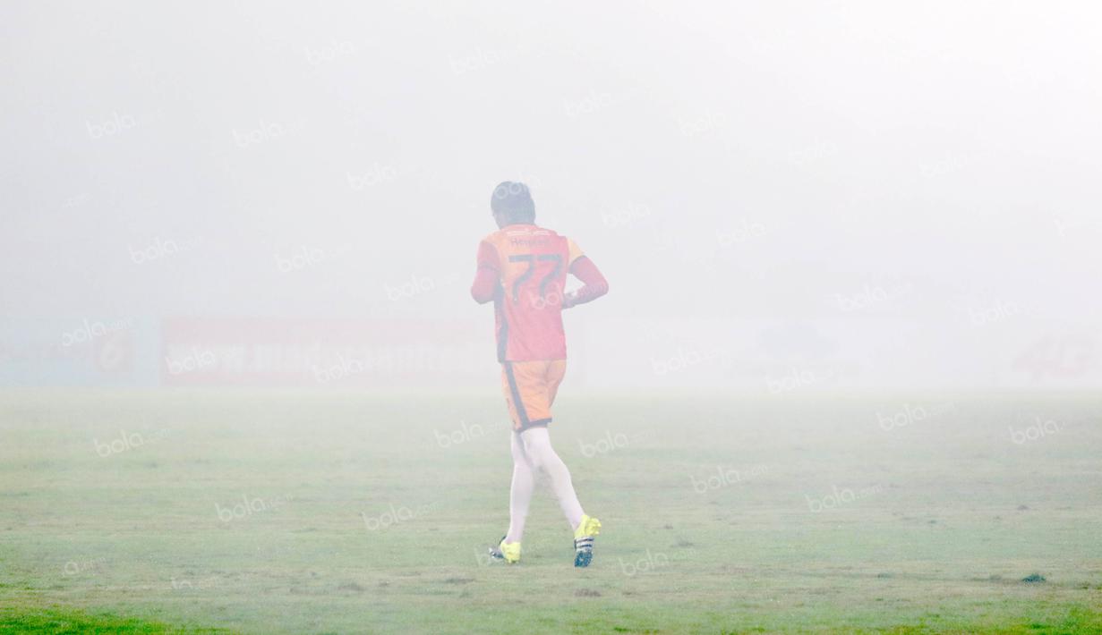 Kiper  Madura United, Hery Prasetyo menembus kumpulan asap dari flare saat melawan Persiba Balikpapan pada laga Torabika SC2016 di Stadion Gelora Bangkalan, Senin(13/6/2016).  (Bola.com/Nicklas Hanoatubun)